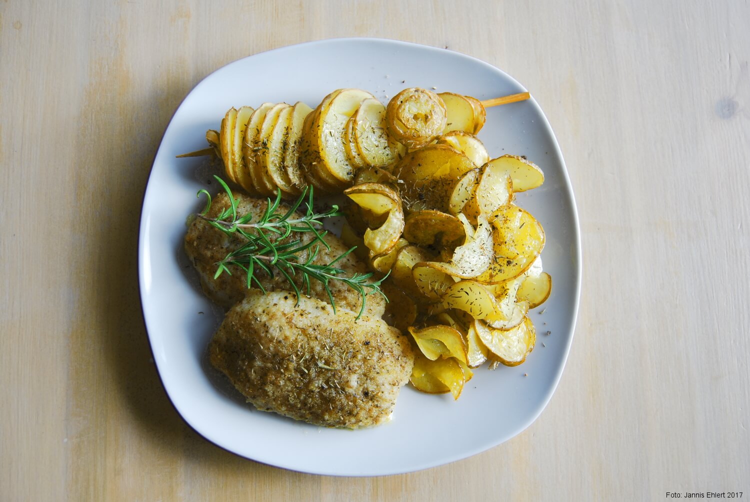 Ein Foto, auf dem Rosmarinkartoffeln auf einem weißen Teller angerichtet sind.